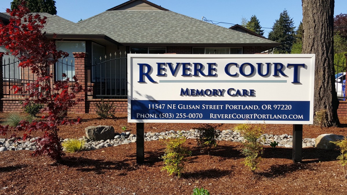 A sign for Revere Court Memory Care facility in front of a building.