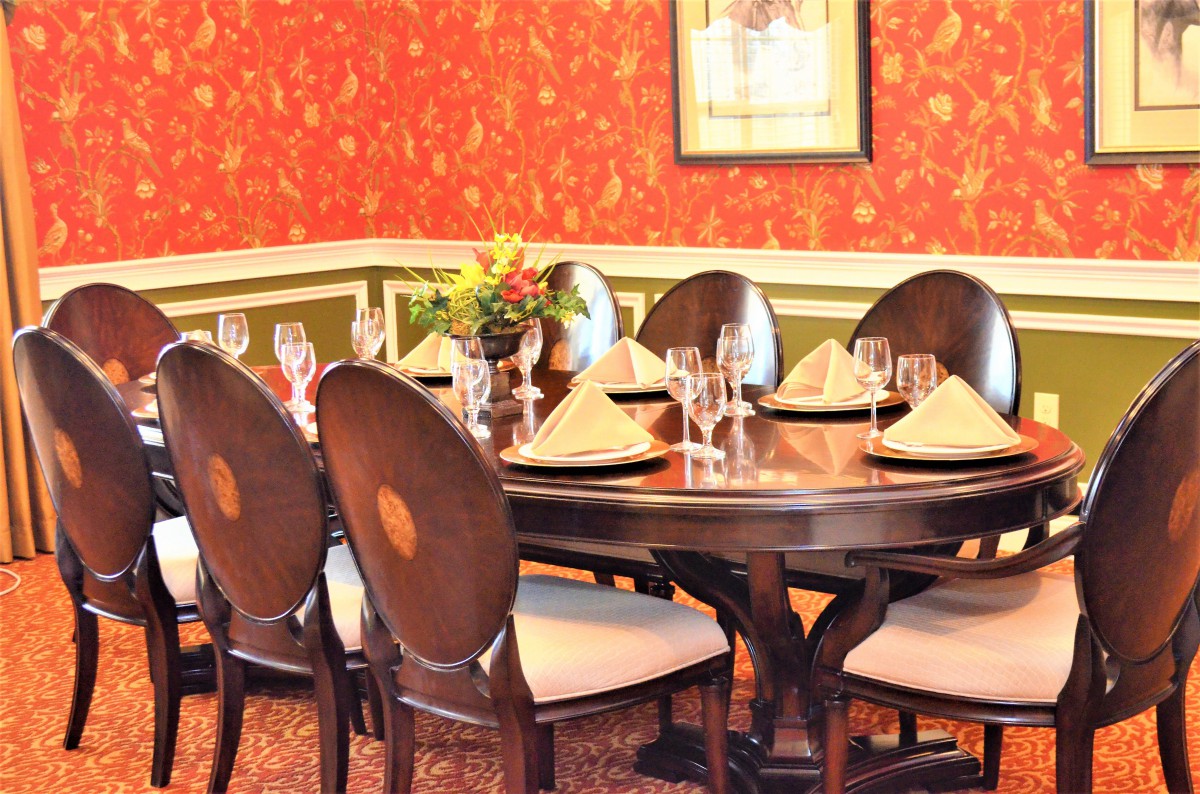 A beautifully set dining table with elegant decor and a flower arrangement.