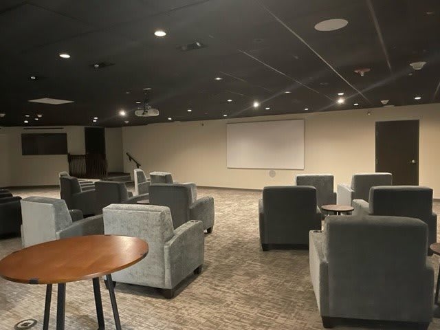 A modern conference room with comfortable seating and a projection screen.