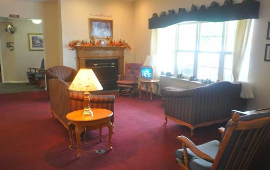A cozy living room with a fireplace, sofas, and a television.