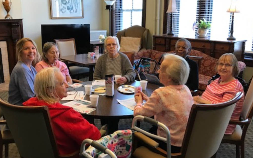 A group of seniors sitting around a table engaged in conversation.