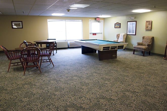 A spacious game room featuring a pool table and seating area.