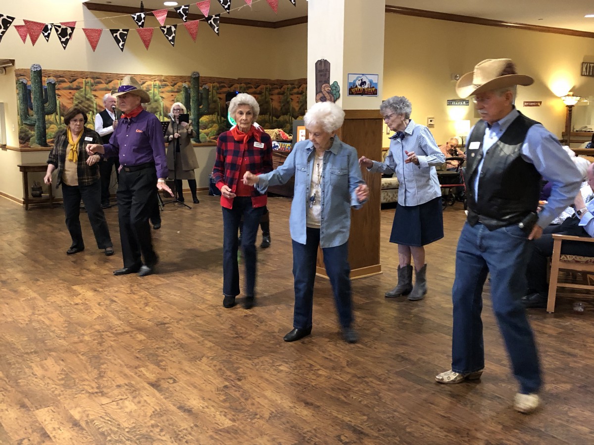 A group of seniors enjoying a dance event indoors.
