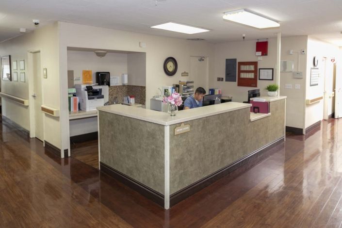 A reception area with people working at desks in an office setting.