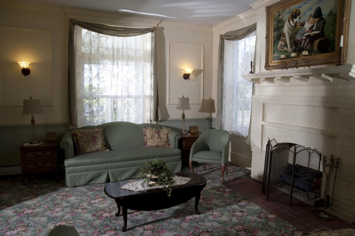 A cozy living room with a classic style, featuring a sofa, coffee table, and a fireplace.