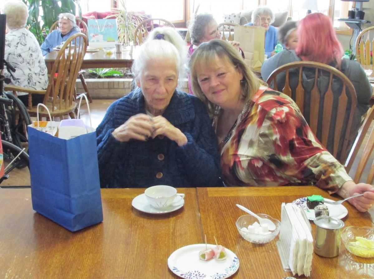 Two women enjoying a cup of tea at a cafe.
