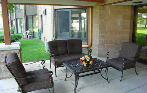 A cozy outdoor sitting area featuring metal furniture and a decorative floral centerpiece.