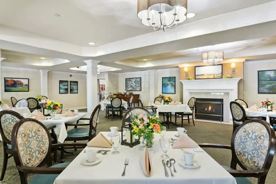 An elegant dining area with beautifully set tables and a cozy fireplace.