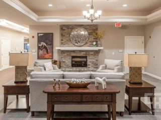 A cozy living room with a central fireplace, comfortable sofas, and elegant decor.