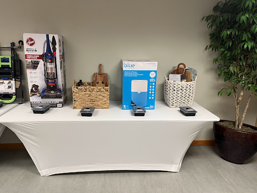 A display table showcasing various home goods including baskets and a vacuum cleaner.