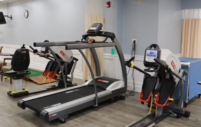 A gym room featuring a treadmill and other fitness equipment.