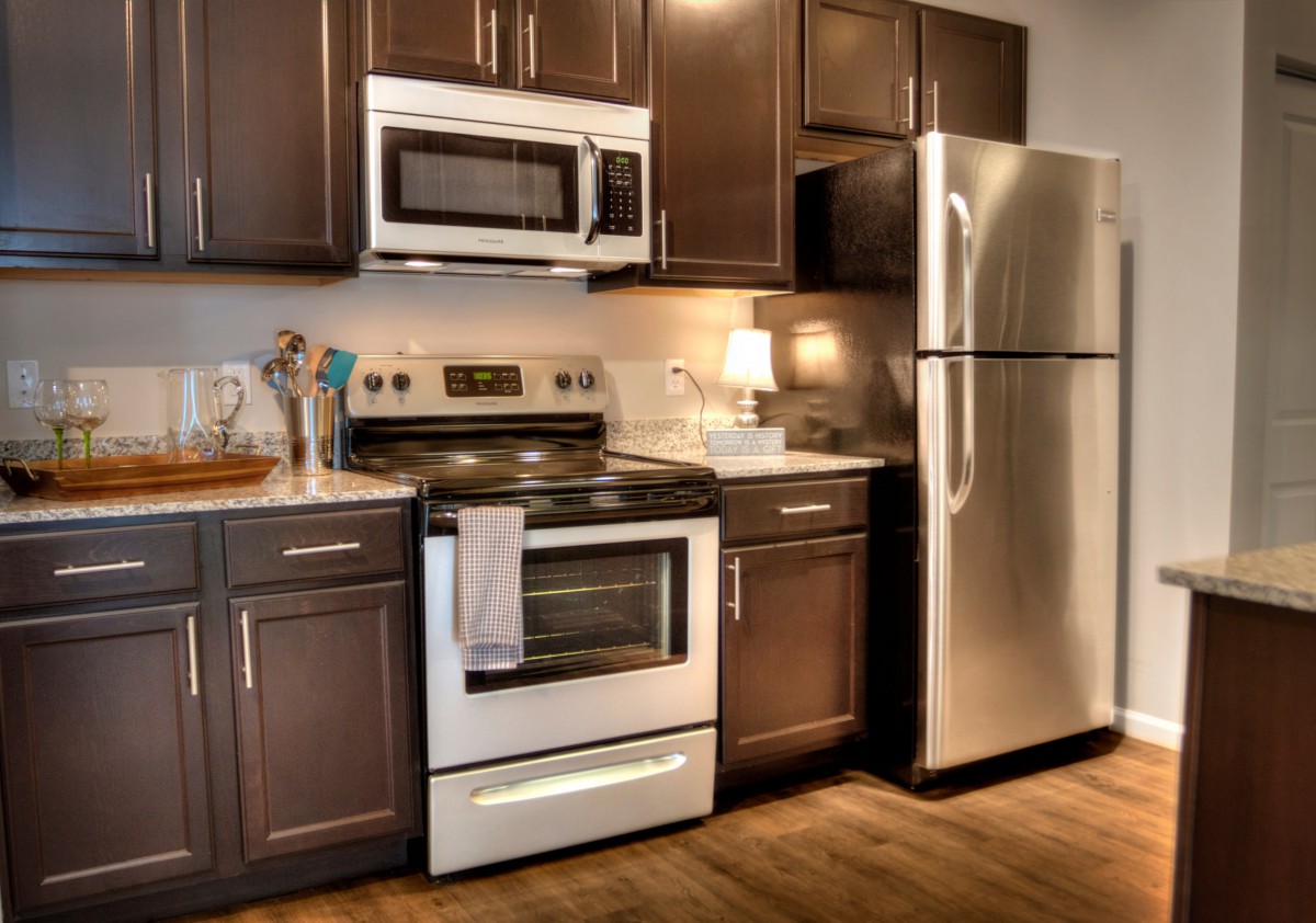 Modern kitchen with stainless steel appliances and dark cabinets.