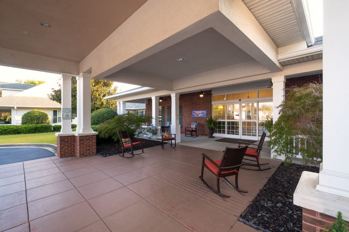 A cozy outdoor porch with rocking chairs under a covered patio.