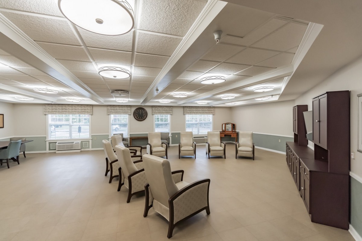 An empty conference room with arranged chairs and ceiling lights.