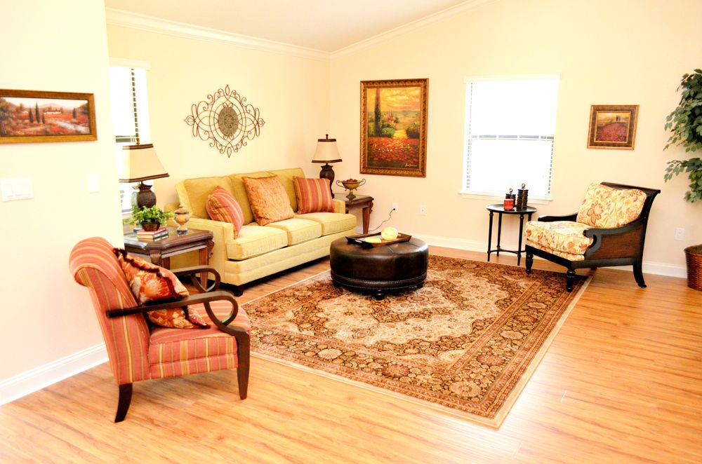 A cozy living room with a sofa, armchair, coffee table, and decorative elements.