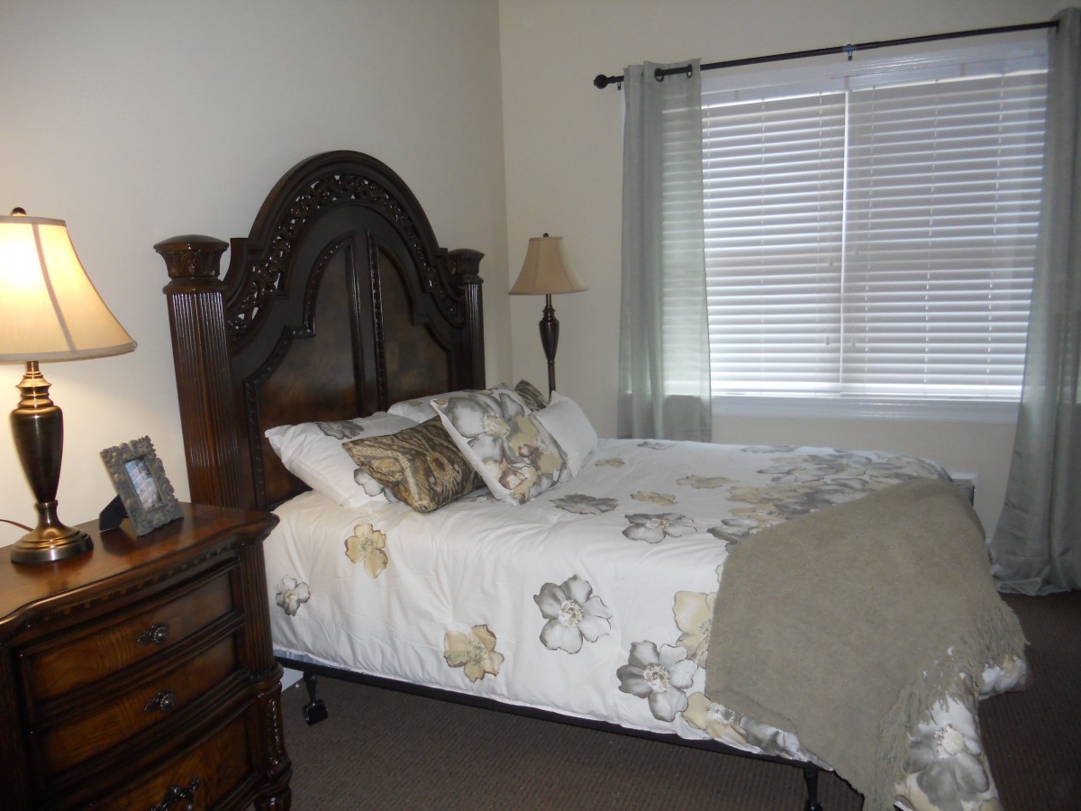 A neatly arranged bedroom with a large bed and elegant decor.