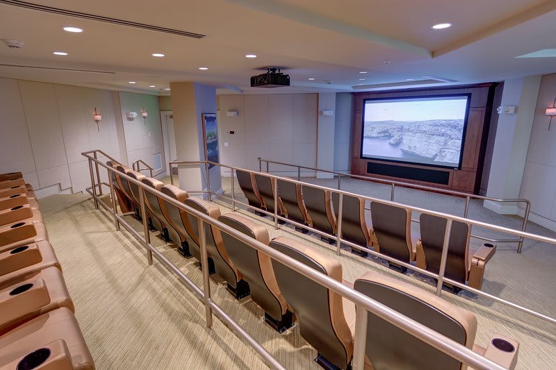 A small auditorium featuring tiered seating and a large projection screen.