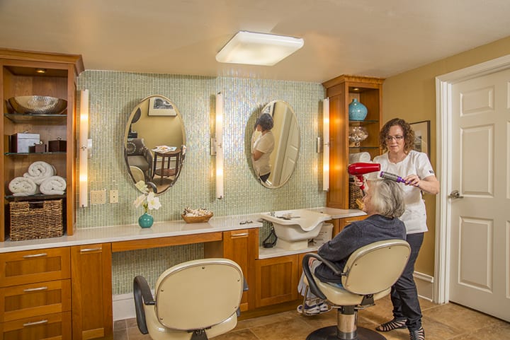 A hair stylist working in a cozy hair salon with modern decor.