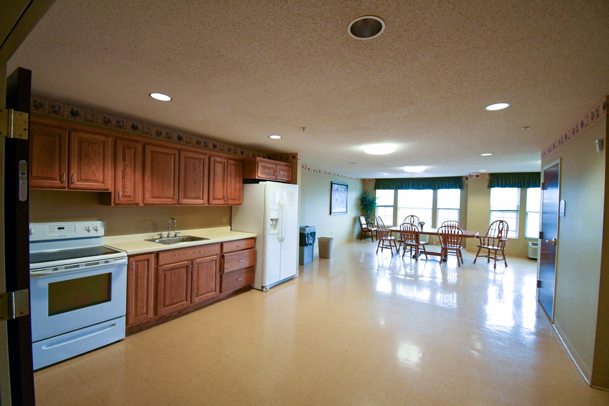 A spacious kitchen and dining area with wooden cabinets and modern appliances.