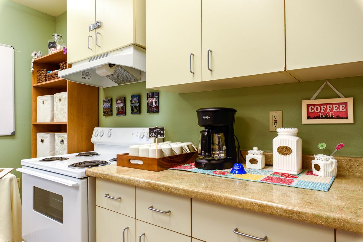 A cozy kitchen setup featuring a coffee maker and neatly organized cabinets.