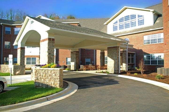 A view of a building entrance with a covered driveway and brick exterior.
