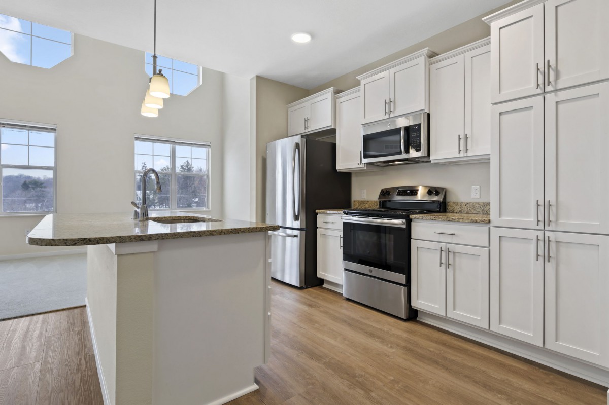 A modern kitchen with stainless steel appliances and white cabinetry.