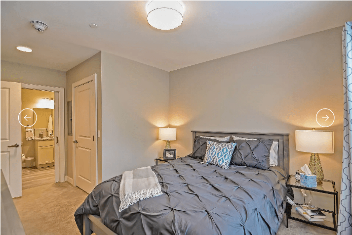 A modern and cozy bedroom with a neatly made bed and soft lighting.