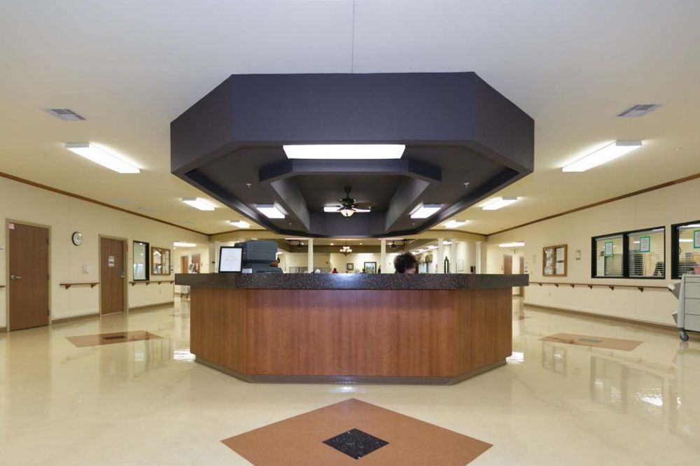 A modern hospital reception desk in a spacious lobby.