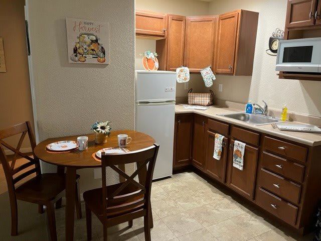 A cozy kitchen with wooden cabinets and a small dining area.