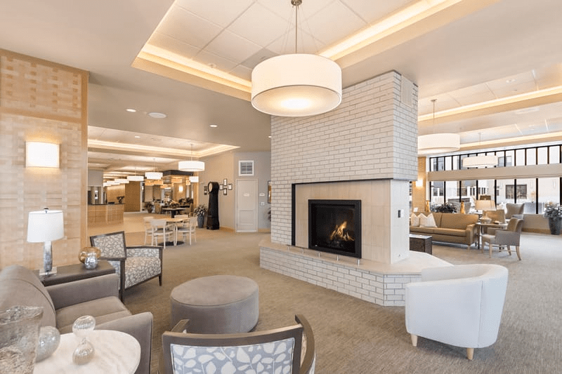 A modern lounge area with a central fireplace and comfortable seating.