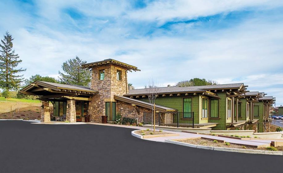 A modern building with a stone and wood exterior set against a blue sky.