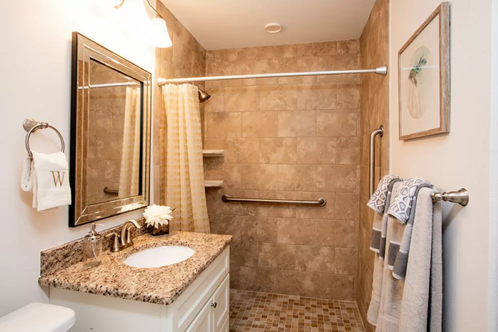 A well-designed bathroom with a walk-in shower, granite countertop sink, and tasteful decor.