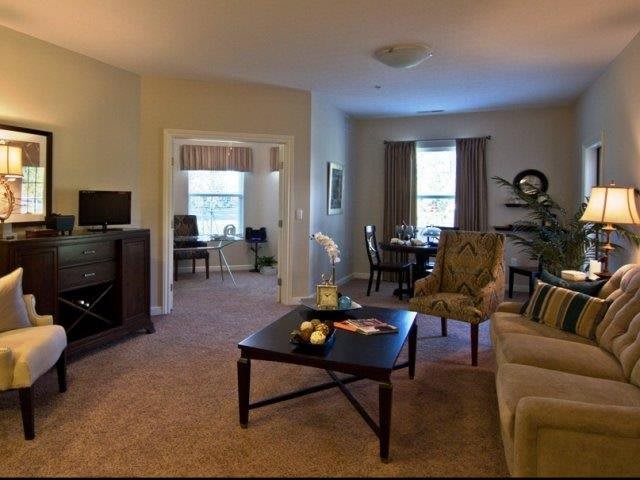A cozy living room with elegant furniture and a connected dining area.