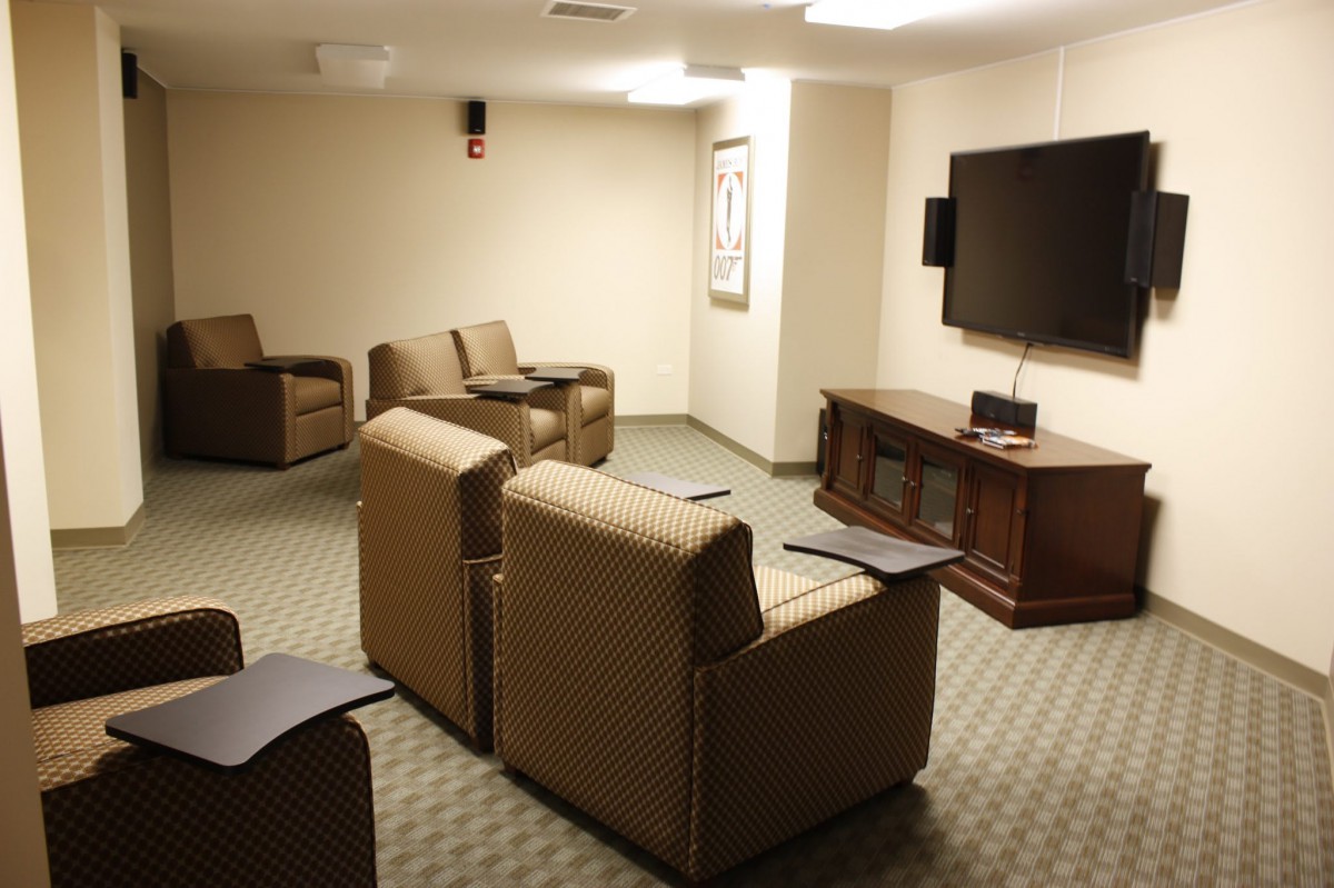A small conference room with multiple chairs facing a large television.