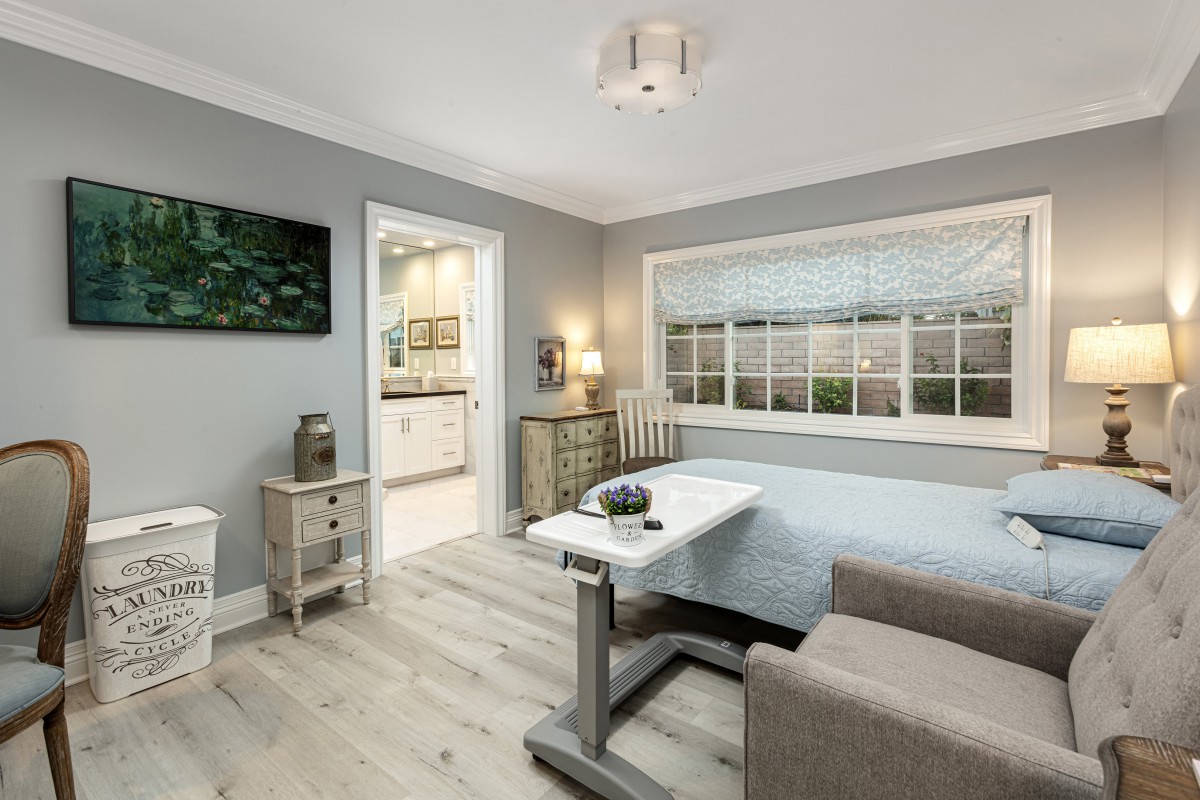 A modern bedroom with grey walls, featuring a daybed and wooden flooring.