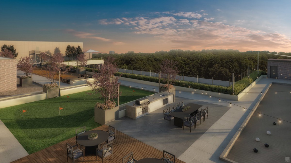 A scenic rooftop with outdoor seating offers a beautiful view of the sunset over the urban landscape.