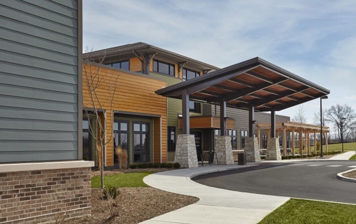 A modern building with a prominent entrance canopy photographed during the day.