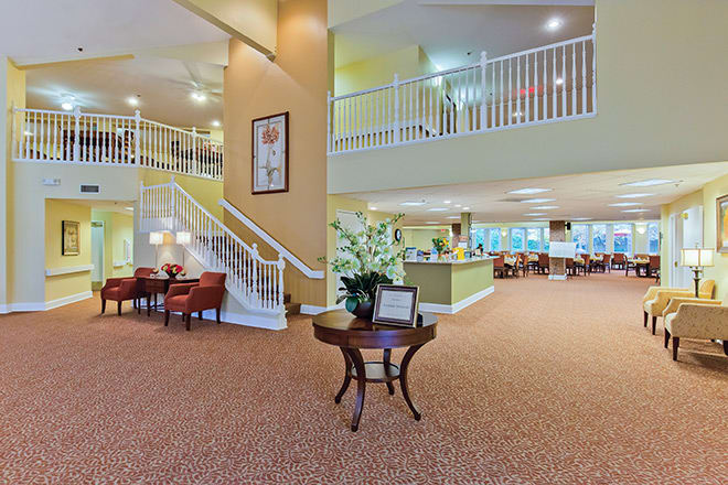 A spacious lobby area featuring a staircase, comfortable seating, and elegant decor.