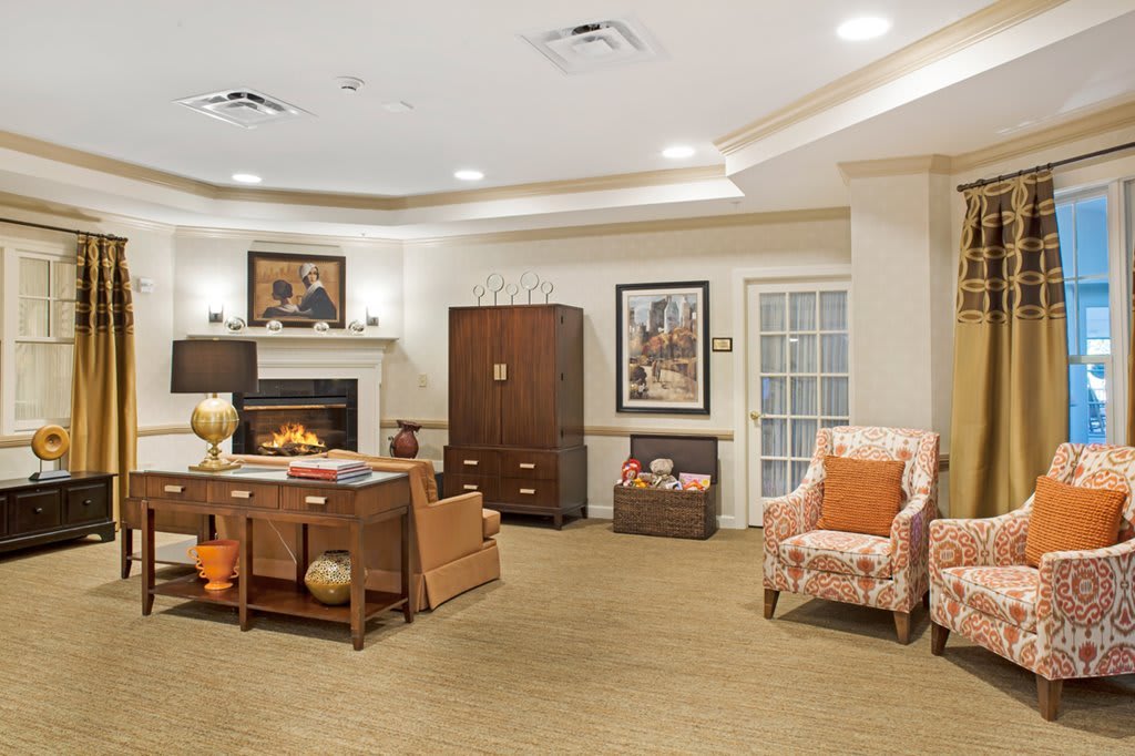 A cozy living room with a fireplace, comfortable seating, and elegant decor.