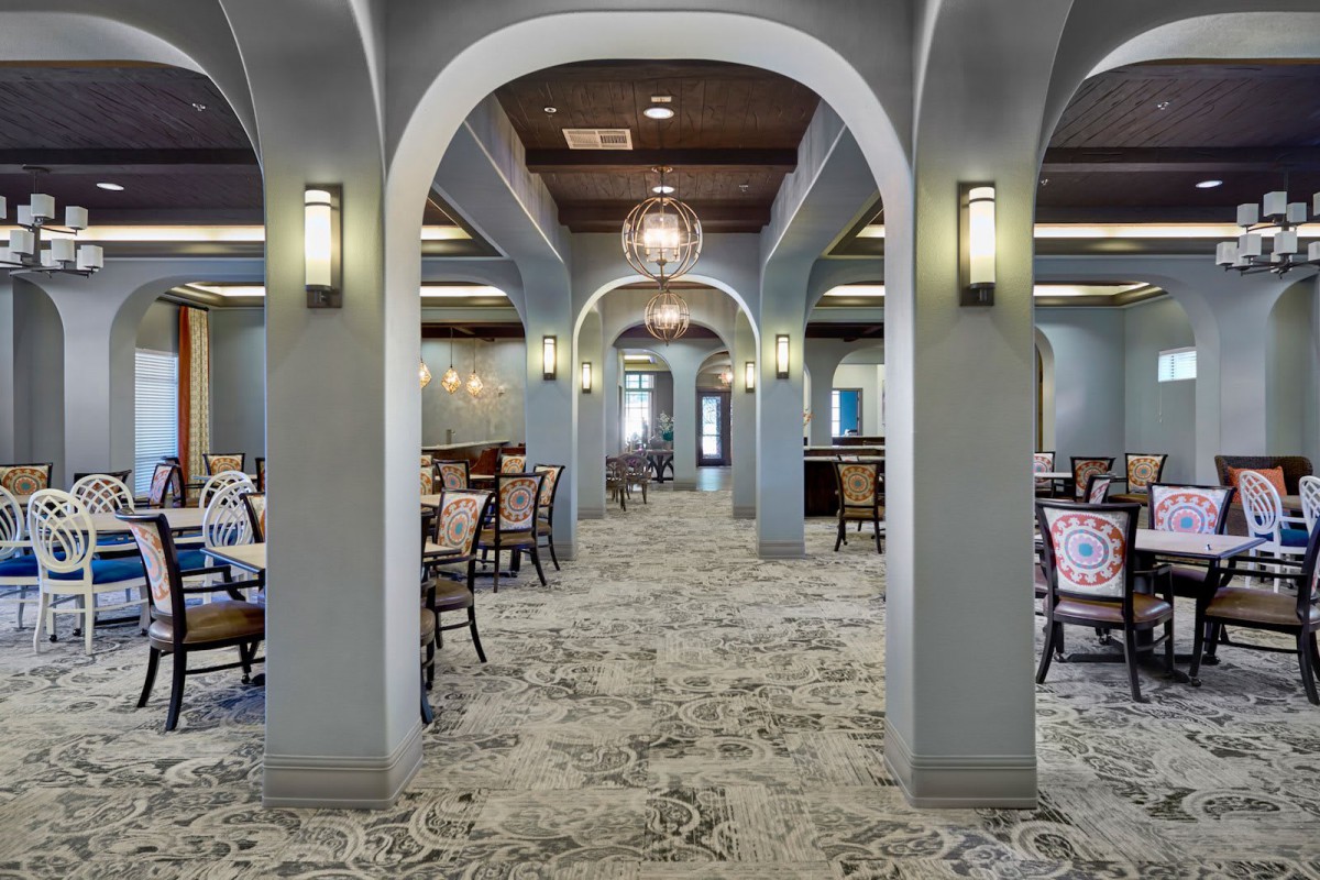 An elegant dining area with arched ceilings and a symmetrical arrangement of tables and chairs.
