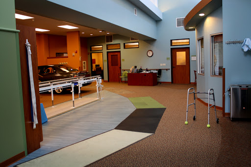 A spacious and brightly lit rehabilitation therapy room equipped for patient exercises.