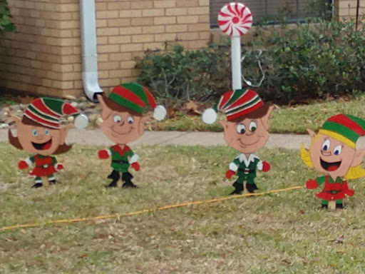A festive display of playful elves in a yard, celebrating the holiday spirit.