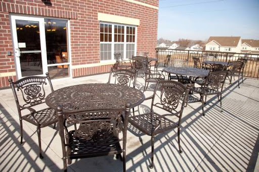 A cozy outdoor seating area featuring intricate metal tables and chairs, perfect for enjoying a meal in the sunshine.