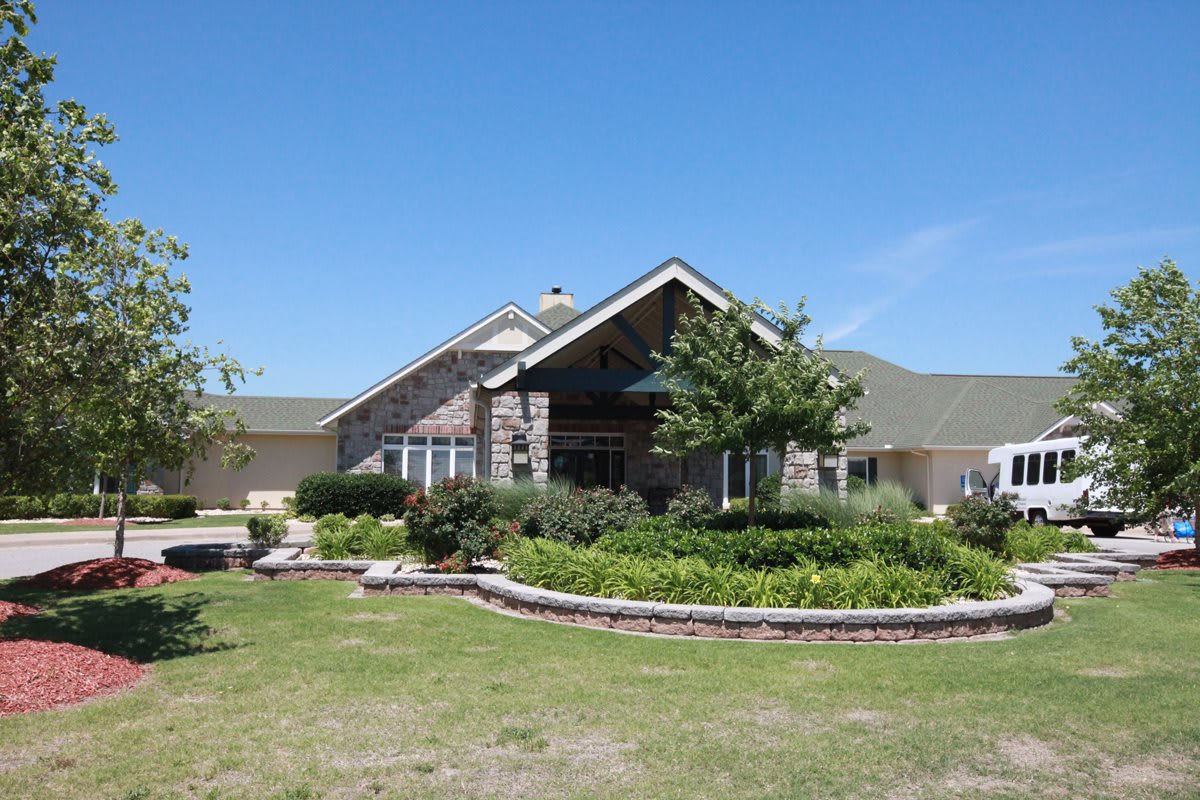 A charming residential house with well-maintained landscaping under a clear blue sky.