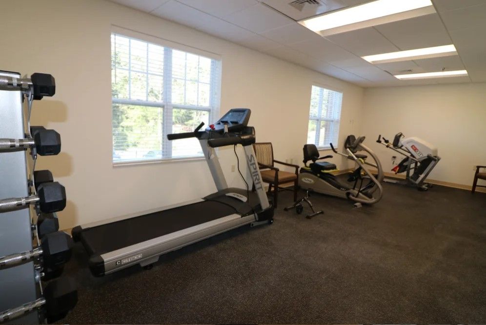 A room featuring fitness equipment, including a treadmill and exercise bikes.