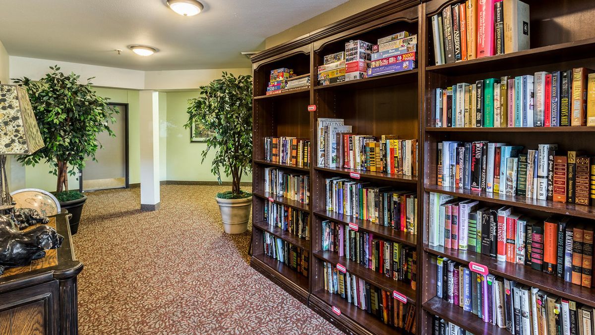 A cozy indoor library corner with a bookshelf filled with books and board games.