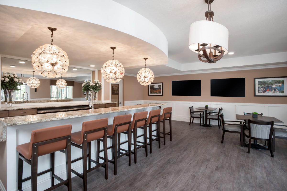 A modern bar interior with high seating and elegant lighting.