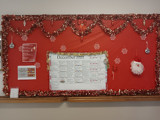 A festive bulletin board decorated with holiday-themed elements and information.