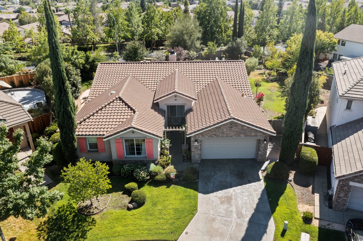 Aerial view of a residential house with a garden and driveway.