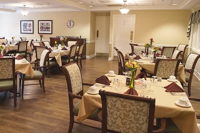 An elegantly set dining room with neatly arranged tables and chairs, ready for guests.